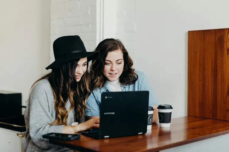 Duas mulheres olhando juntas a tela de um notebook